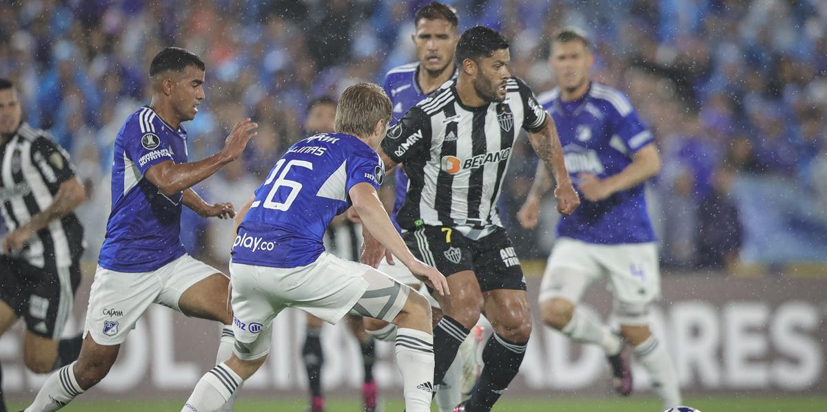 Hulk cercado de jogadores do Millonarios, na última partida do Galo na altitude (Foto: Pedro Souza / Atlético)