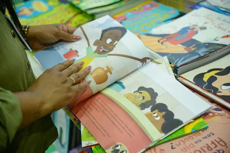 Mulher vê livro infantil na 20ª Bienal do Livro do Rio de Janeiro, no Riocentro, na Barra da Tijuca, zona oeste da capital fluminense (Foto de Arquivo/Tomaz Silva/Agência Brasil)