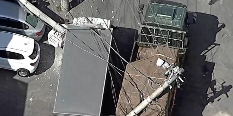 Dois caminhões e um carro foram atingidos pelo poste derrubado pela empilhadeira em Contagem (Reprodução/ TV Globo)