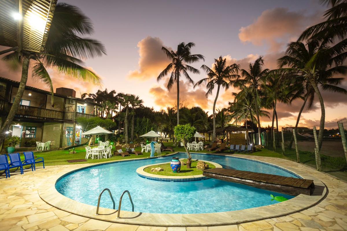 Ideal para famílias e casais, a pousada oferece chalés aconchegantes com vista para o mar, piscina, salão de jogos e áreas verdes que convidam ao descanso e ao lazer (Divulgação/Colmeia Chalés)