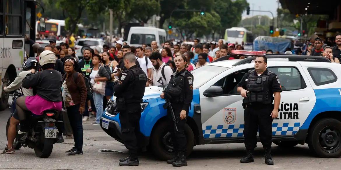 Durante operação policia contra o Comando Vermelho, agentes da polícia militar fazem guarda perto de filas nos pontos de ônibus e vans de transporte complementar na região da Central do Brasil, com trabalhadores sendo liberados mais cedo pela situação de violência (Fernando Frazão/Agência Brasil)