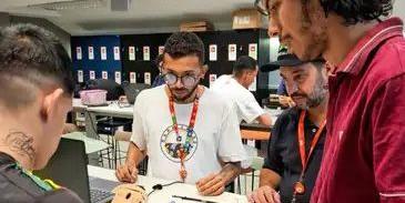 Daniel Messias, Henrique Foresti e Rafael Cavalcante (da esquerda para a direita) acompanham jovem egresso de unidade de internação (de costas) em projeto de robótica (Cesar/Divulgação)