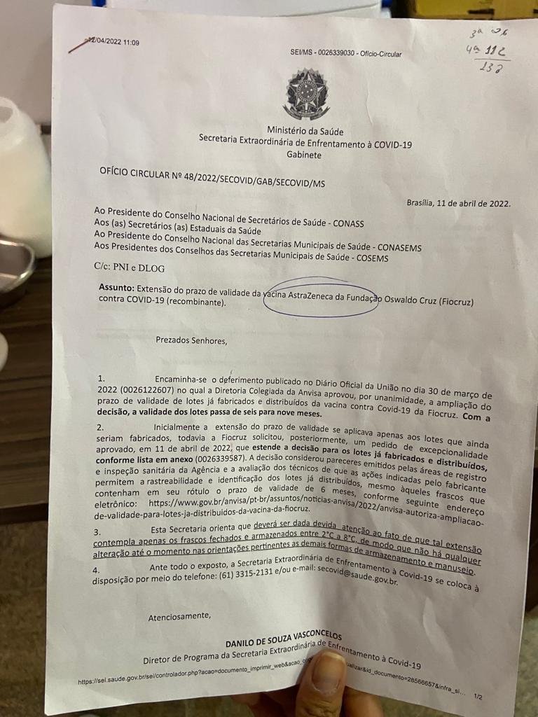 Atendente de ponto de vacinação contra a Covid-19 mostra documento do Ministério da Saúde que informa usuário sobre prorrogação da data de validade do imunizante (Luciane Amaral)