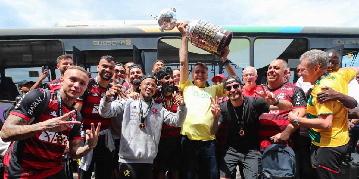 Jair Bolsonaro ergueu a taça da Libertadores ao lado de jogadores do Flamengo (Divulgação/Flávio Bolsonaro)
