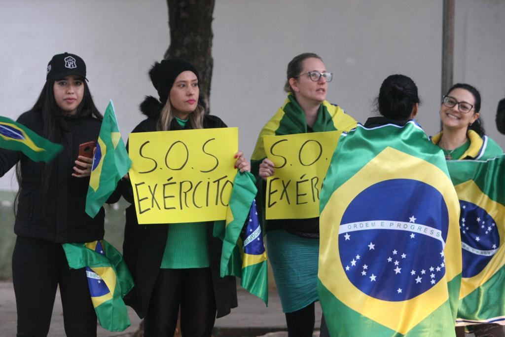 Mulheres com a bandeira do Brasil fazem protesto na porta do 12º Batalhão de Infantaria Leve de Montanha, no Barro Preto (Maurício Vieira / Hoje em Dia)