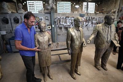 Artista Léo Santana com a estátua de Henriqueta Lisboa, uma das mais danificadas (Rodrigo Clemente/PBH/Divulgação)